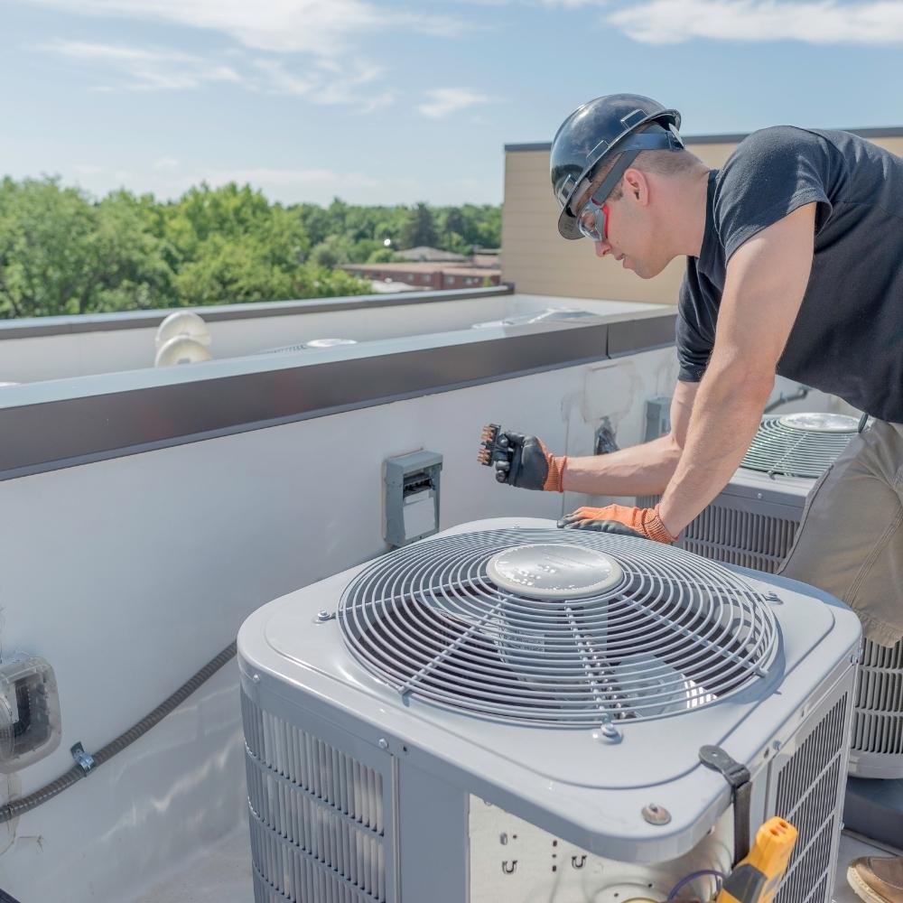 Membership 1 A member working on an air conditioner on a roof.